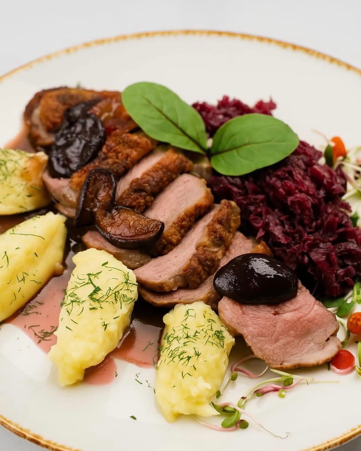 Pierś z kaczki (200g) podana z ziemniakami puree, czerwoną kapustą gotowaną z sokiem z aronii i czarną porzeczką (300g)